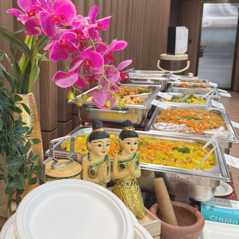 Thai buffet display with orchids and traditional figurines